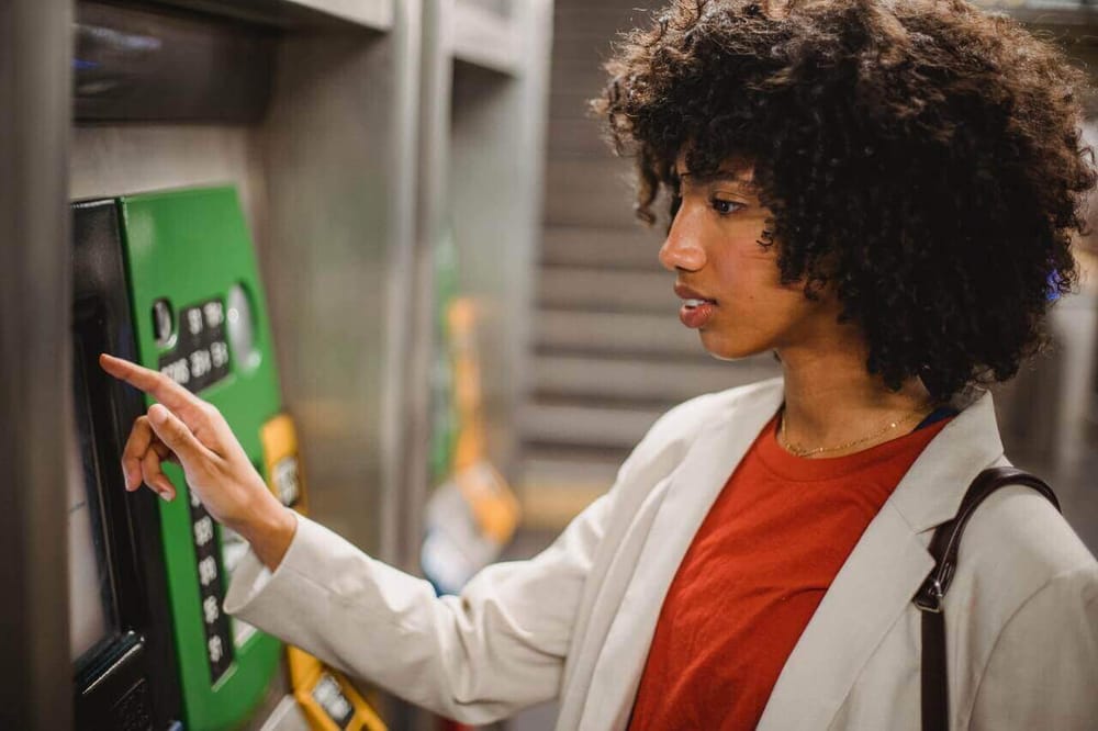 A happy girl with card at an ATM